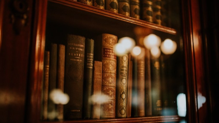 Старые книги в застеклённом книжном шкафу